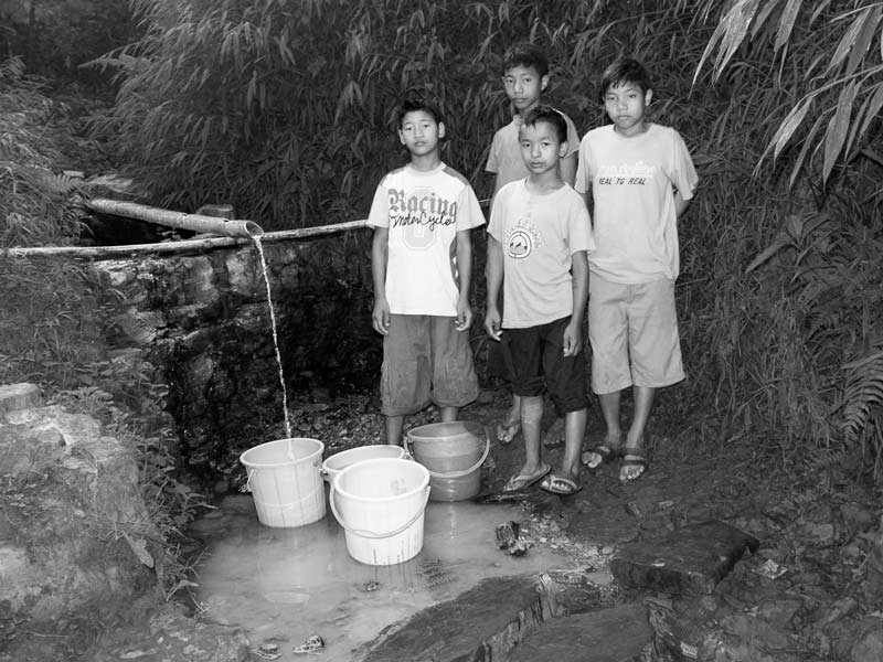 Traditional water supply science and technology of India - Water being procured by Konyak tribal children from a hillside spring in Mon district, Nagaland